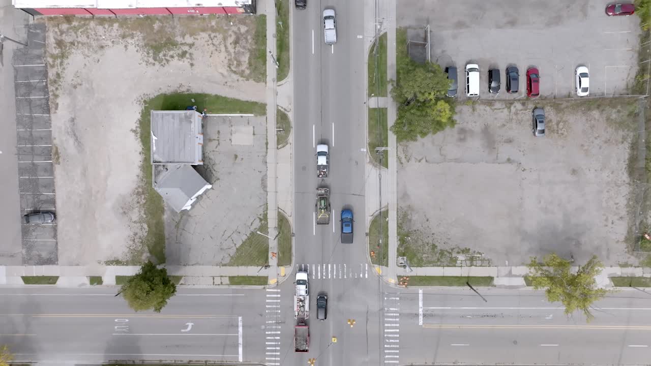 coches moviéndose en la intersección de la calle cedar y la autopista saginaw en lansing, michigan con el video de drones aéreos siguiendo