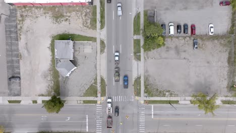 Automóviles-Que-Se-Mueven-En-La-Intersección-De-Cedar-Street-Y-Saginaw-Highway-En-Lansing,-Michigan,-Con-Un-Video-De-Drones-Aéreos-Siguiendo