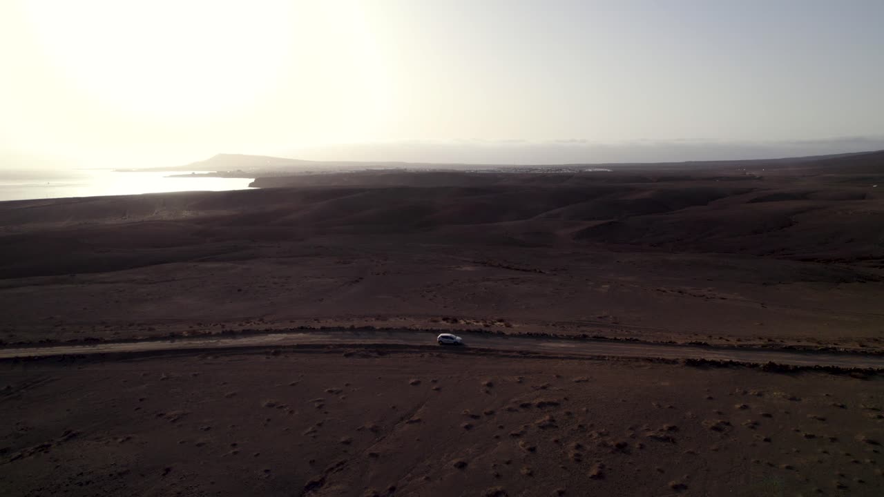 vista aérea de los coches que conducen por la carretera del desierto, el tiempo al atardecer y la costa