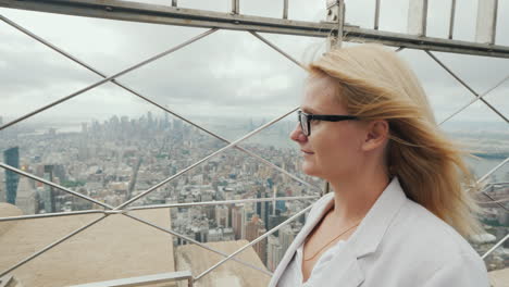 vista trasera de una mujer admirando la ciudad de nueva york desde un punto alto