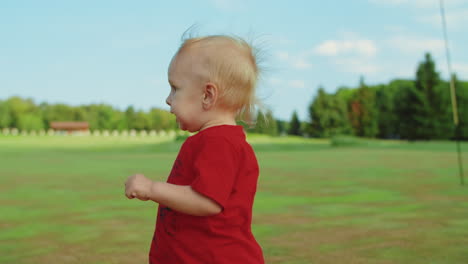 boy running in green meadow