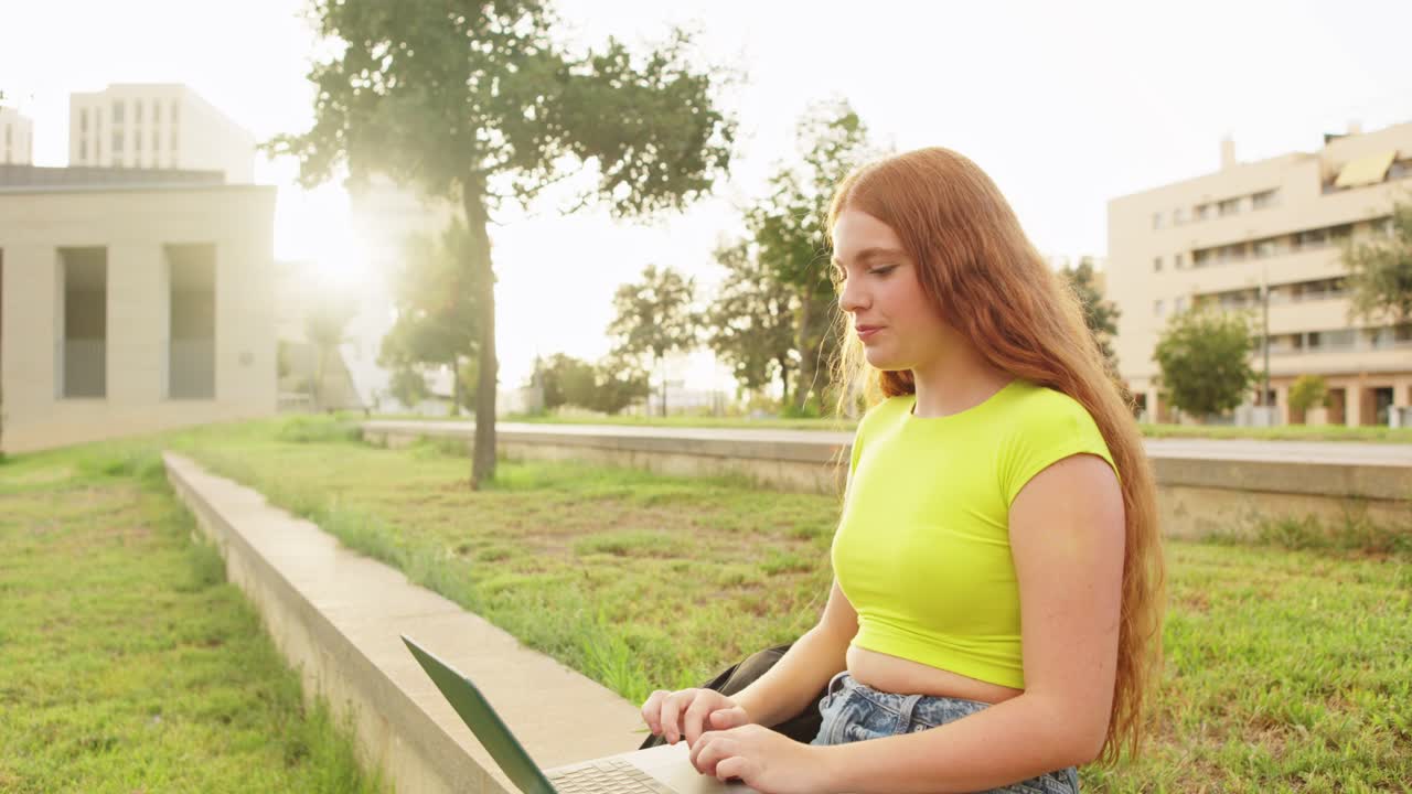 Woman using laptop in a park