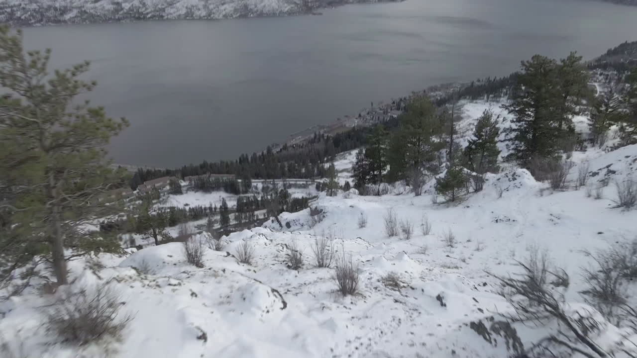 눈 덮인 언덕 위에 있는 사람의 공중 전망과 캐나다 브리티시 컬럼비아 오카나간 호수의 킬로나와 오카나간 호수의 겨울 풍경의 관점