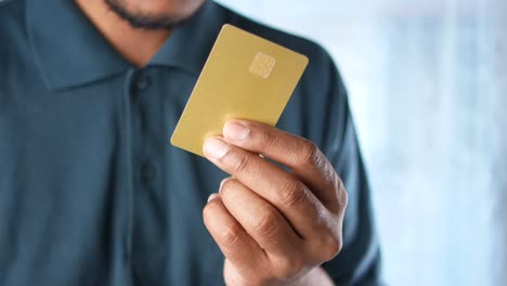 man in casual dress showing credit card