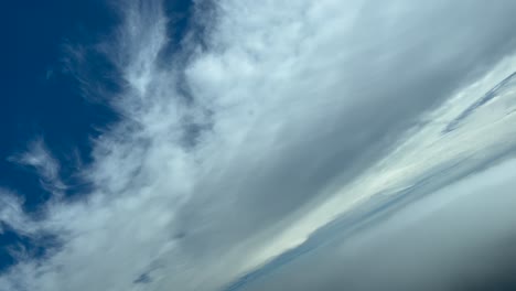 immersive pilot’s pov flying between layers of white fluffy frayed clouds as seen by the pilots of a jet climbing and doing a right turn in a turbulent blue sky. 4k