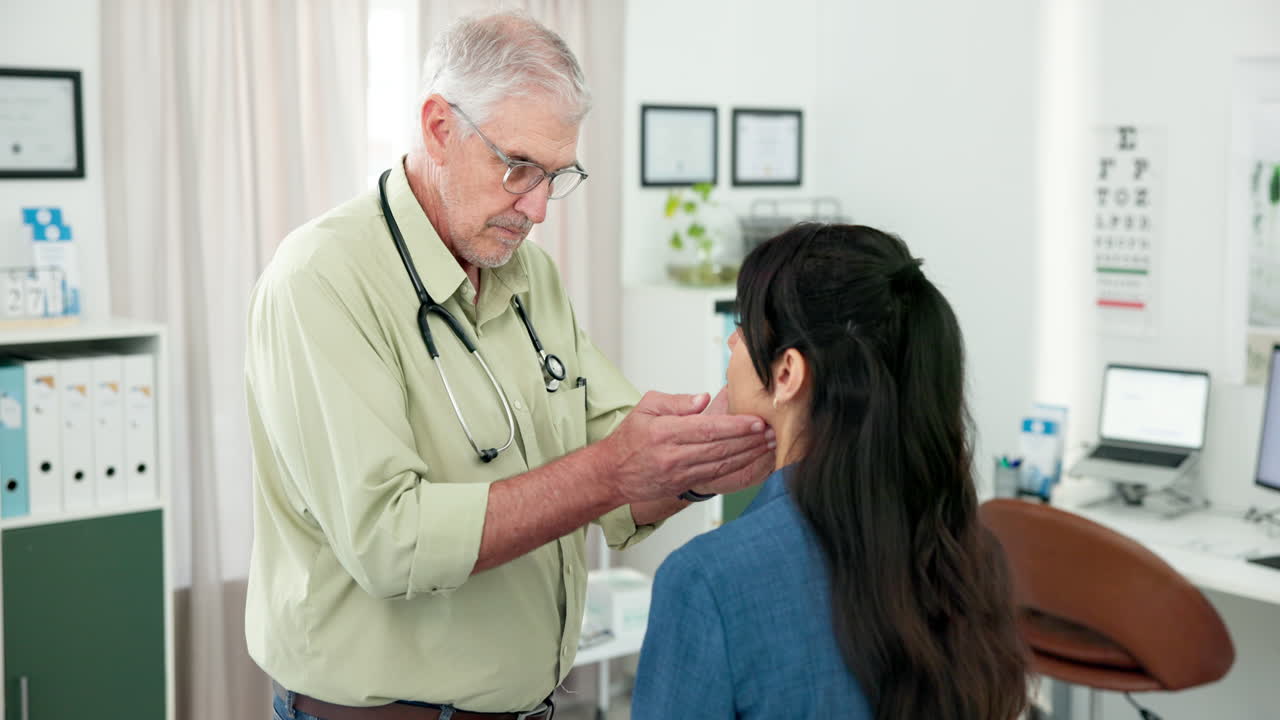 Senior Doctor Examining a Woman's Neck in a Medical Office