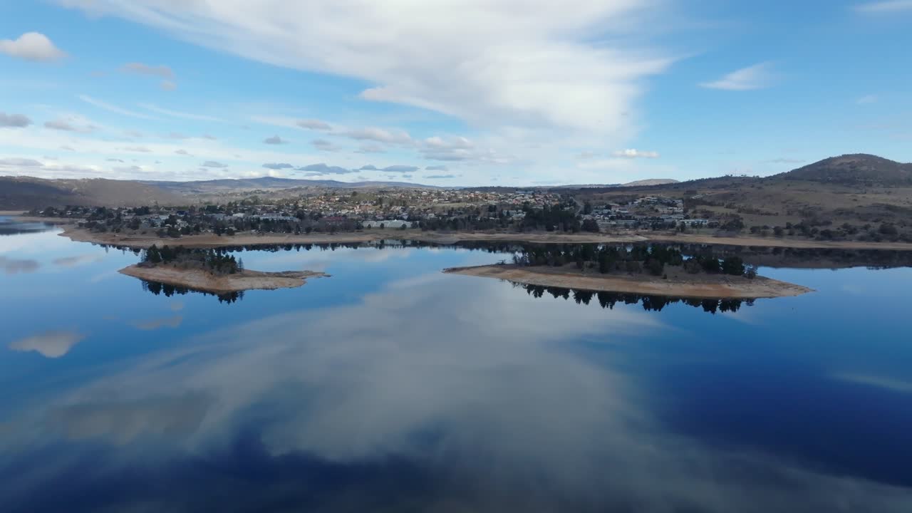 Aerial: Drone shot flying over lake Jindabyne and islands towards the town, NSW, Australia