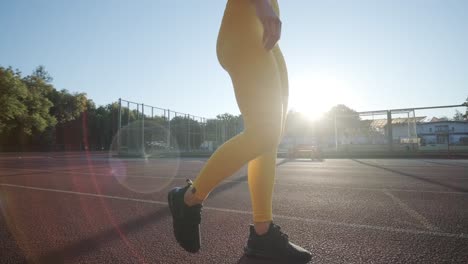 woman jogging on outdoor track in sportswear at athletic field