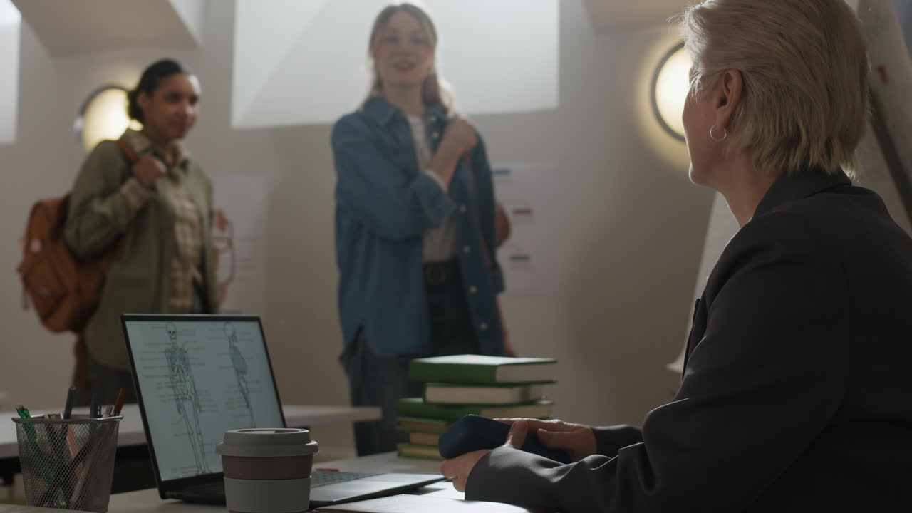 Classroom scene with students, teacher, and laptop displaying anatomy
