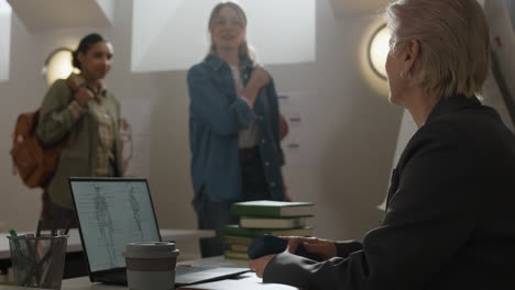 classroom scene with students, teacher, and laptop displaying anatomy