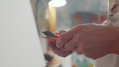 manos masculinas afilando el lápiz con un cuchillo