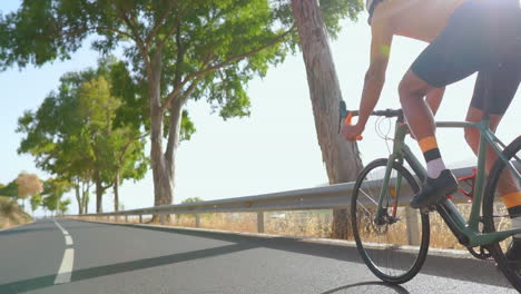 En-Una-Carretera-Matutina-Vacía,-Un-Hombre-En-Bicicleta-De-Carretera-Participa-En-Ejercicio-Al-Aire-Libre.-El-Vídeo-En-Cámara-Lenta-Enfatiza-El-Concepto-De-Deportes-Extremos.