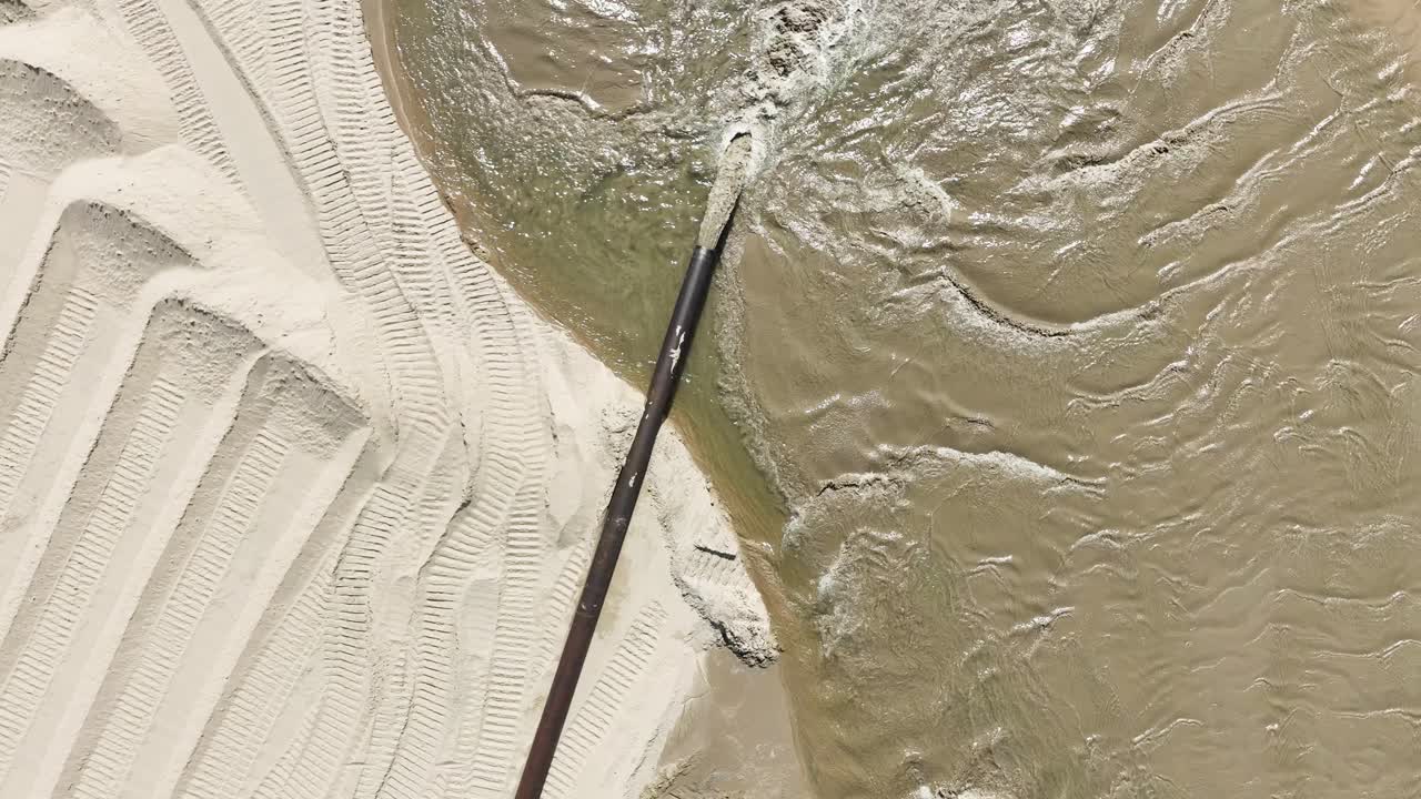 A pipe transporting sand in direct aerial, camera rising