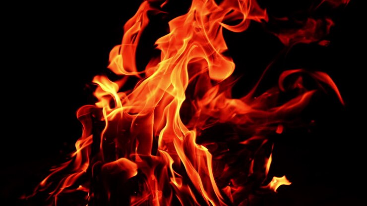 Fiamma rossa su sfondo scuro. Legna da ardere, bellissimo scenario