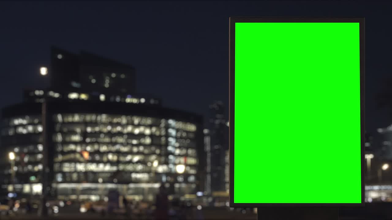 Cartellone pubblicitario con schermo verde su un'autostrada trafficata con traffico, luci al neon