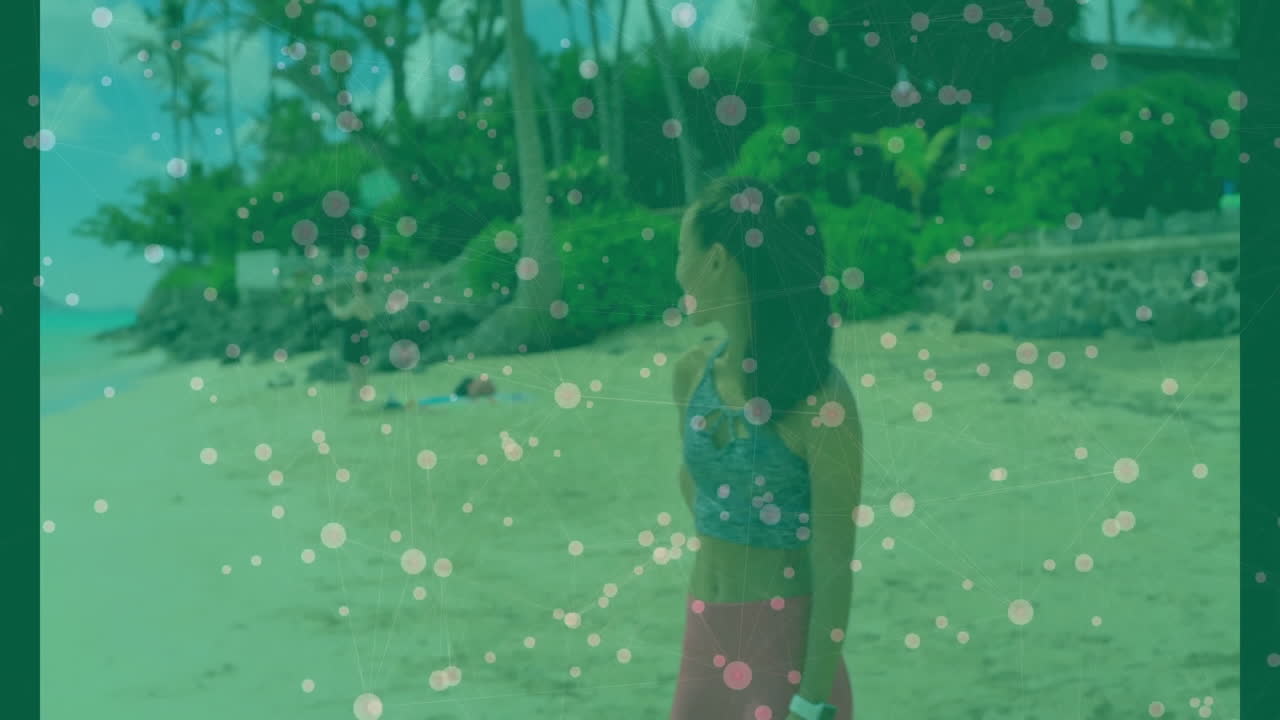 Standing on beach, woman surrounded by colorful bubbles in scenic view