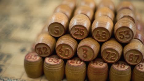 cinematic creative close-up smooth backwards macro shot of bingo wooden barrels in a row, woody figures, old numbers background, vintage board game, slow motion 120 fps commercial gimbal video