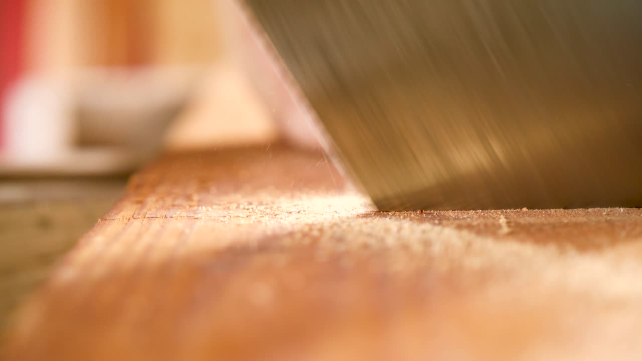 primer plano de una sierra cortando un trozo de madera contrachapada