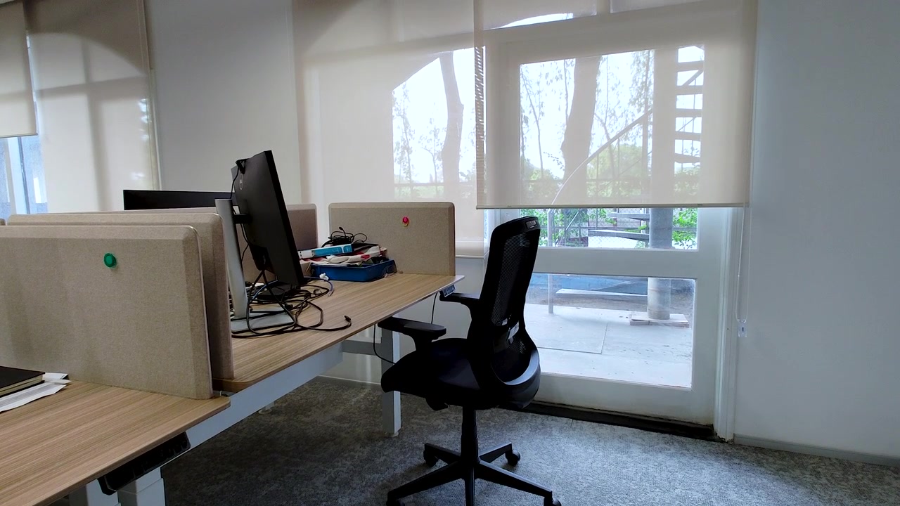 Spazio di lavoro moderno per ufficio aziendale con scrivania per computer, sedia ergonomica e luce naturale. Ideale per affari, lavoro ibrido, cultura d'ufficio, produttività e concetti di ambiente di lavoro.