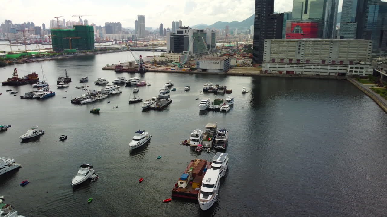 Ariel drone orbit over boat tracking pier reveal city building Hong Kong 4k yacht boat parking pier.
