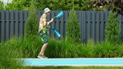 hombre jugando con aletas junto a la piscina