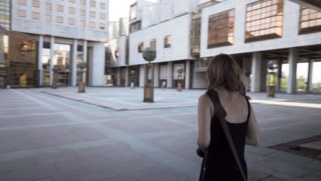 woman with camera walking in a city courtyard