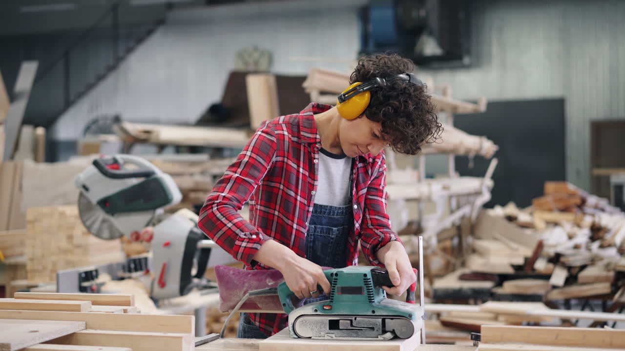 Woman Woodworker Using Belt Sander in Workshop