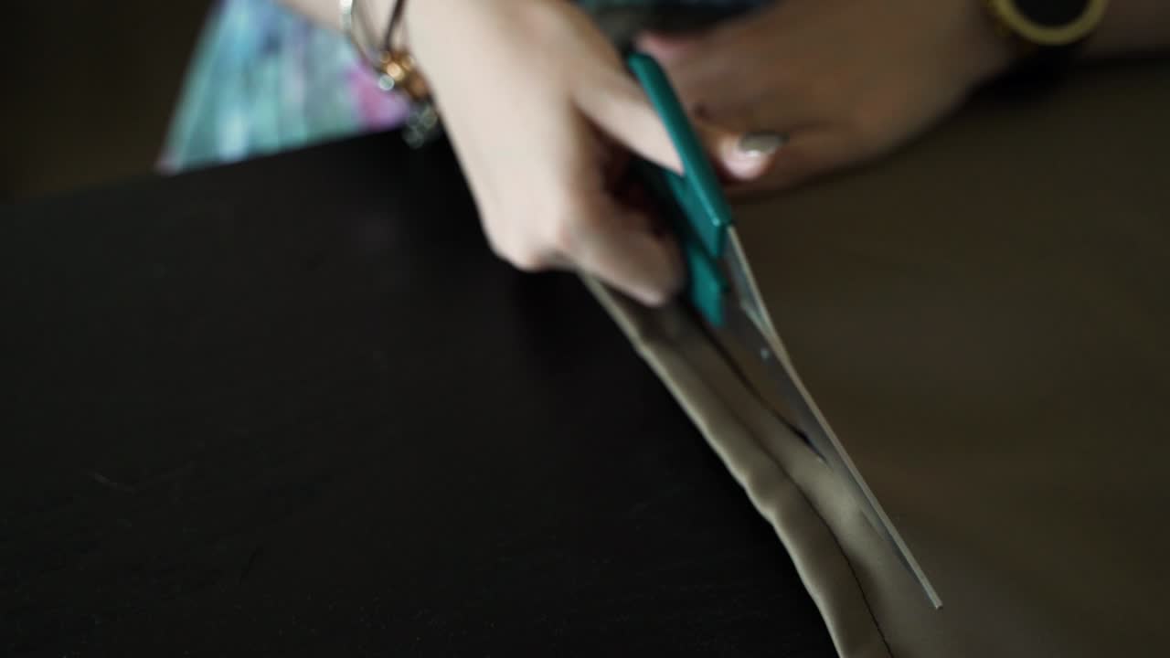 de manos de mujer cortado material para coser en casa, vista de cerca