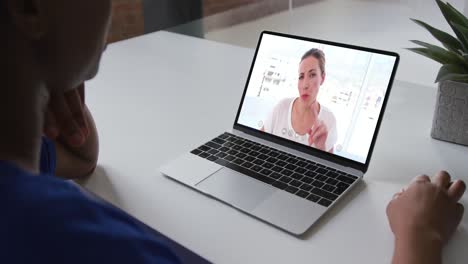 African-american-woman-talking-on-video-call-with-female-colleague-on-laptop-at-office