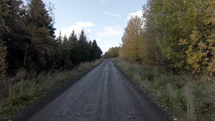 Auto che compare sulla strada, passando una baita abbandonata, atmosfera autunnale
