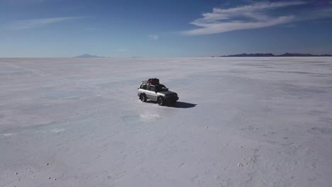 tracking shot of a vehicle driving through the bolivian salt flats