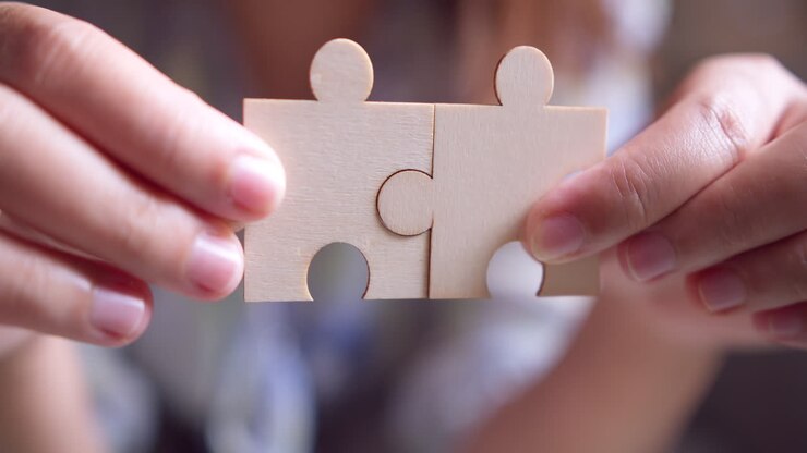 Mano di donna d'affari che unisce un puzzle con effetto luce solare, concetto di soluzioni aziendali, successo e strategia