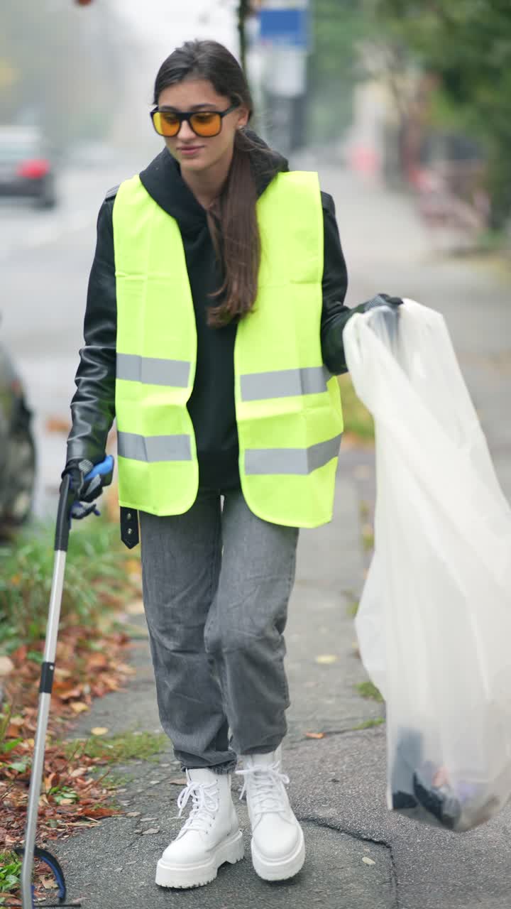 mujer limpiando la basura en la calle
