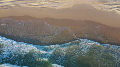 aerial view above waves at the k'gari beach on fraser island, in sunny australia - top down, drone shot