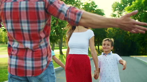 happy mother with children walking in park. family meeting father outdoors