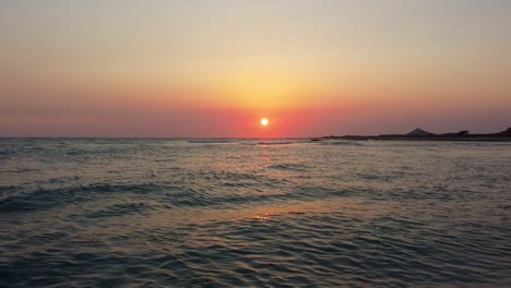 Vuelo-De-Bajo-Nivel-En-La-Superficie-Del-Mar-Aguas-Poco-Profundas-Color-Naranja-Puesta-De-Sol-Noche-En-La-Playa-Puerto-Resort-Costero-Camping-Actividad-De-Naturaleza-Pacífica-En-Irán-Qatar-Frontera-Isla-De-Hormuz-Atracción-Icónica