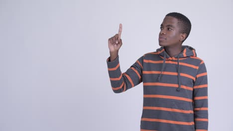 joven feliz y guapo hombre africano pensando y señalando hacia arriba