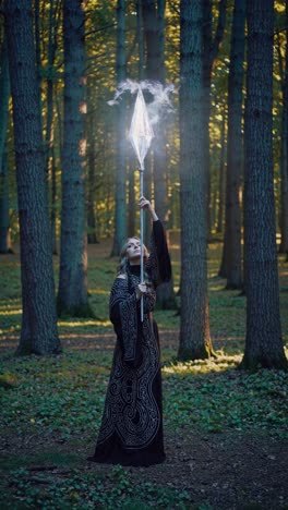 a woman in a forest holding a staff, wearing a detailed robe. the low-angle shot adds a mystical