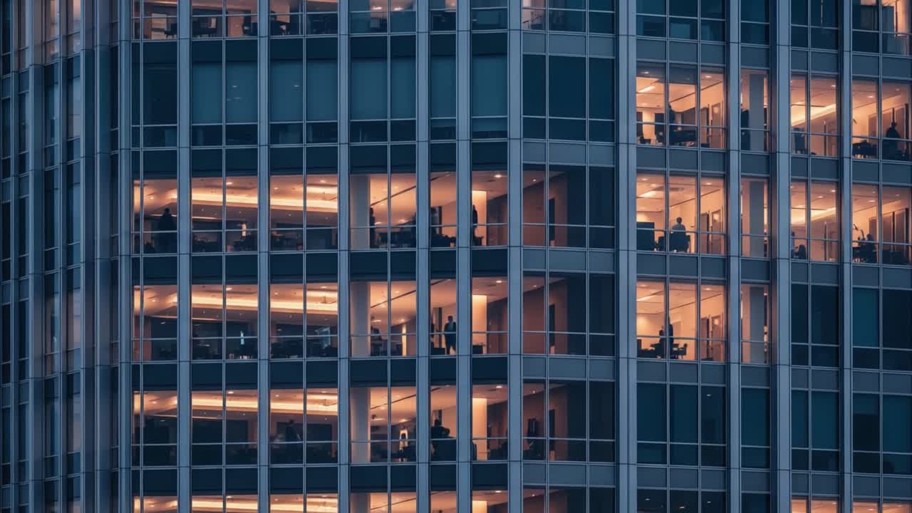Illuminated office building at night with people working