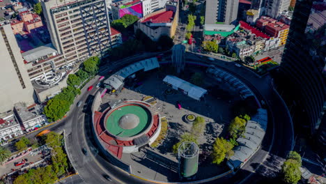 Aerial-orbit-hyperlpase-of-the-Glorieta-de-Insurgentes-subway-station-with-cars-and-public-transport-movement