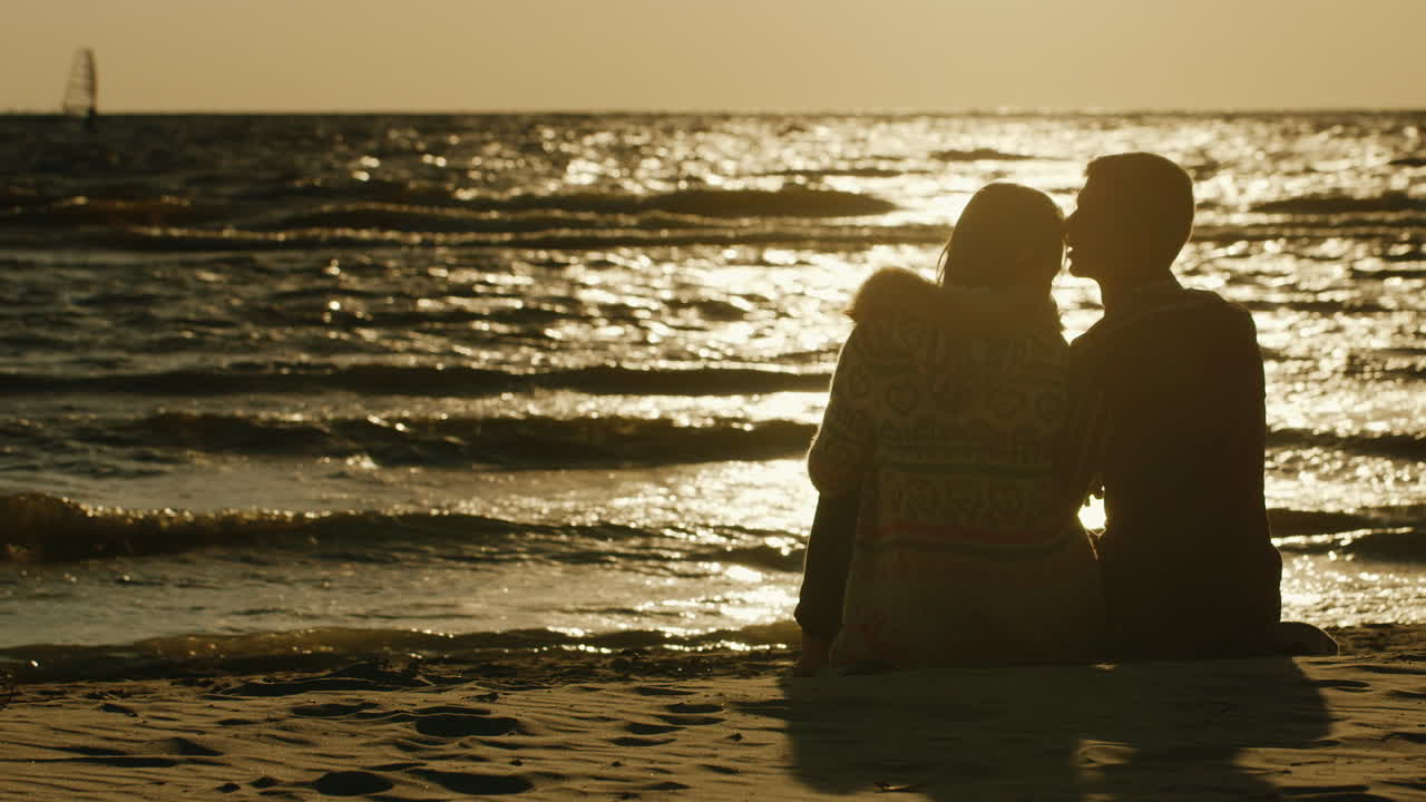 바다와 일몰 바다 수영 윈드 서핑을 감상하는 모래에 함께 앉아 사랑하는 부부