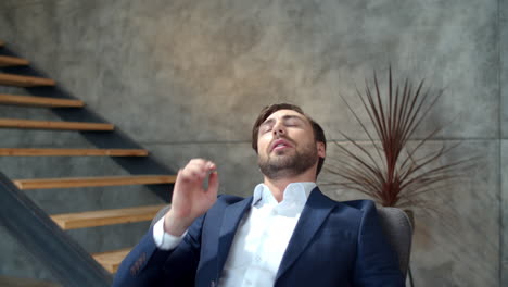 tired businessman relaxing after work on laptop at remote office