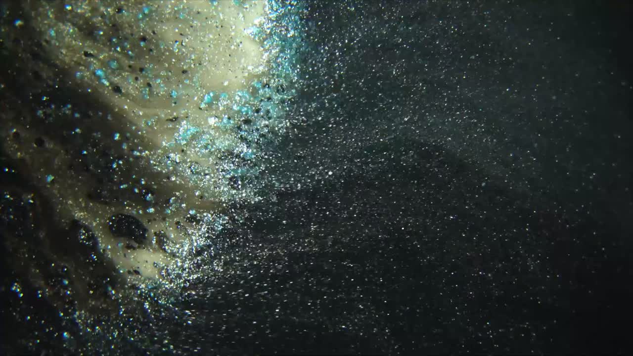 Particules scintillantes abstraites tourbillonnant dans un liquide sombre