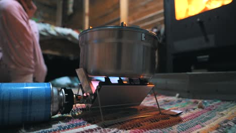 Cocinar-Pasta-Con-Una-Estufa-De-Gas-Portátil-En-Una-Cabaña-En-La-Naturaleza,-Al-Aire-Libre,-Acampar