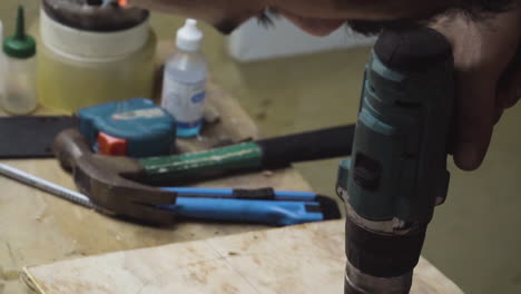 skateboard maker drilling holes on wood plank using a cordless driller