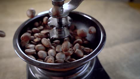 Coffee-beans-fall-in-the-old-grinder.-Slow-motion-with-rotation-tracking-shot.