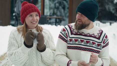 Caucasian-man-giving-hot-tea-for-his-woman-in-winter-day-outdoors.