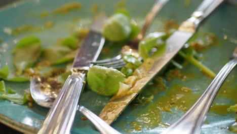 a dirty plate with a fork, knife, and spoon