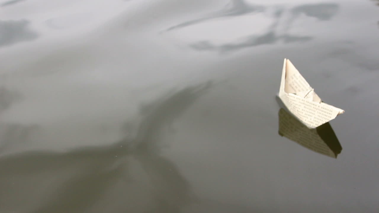 Paper Ship In Children Hand. The boy launches a paper boat into the water