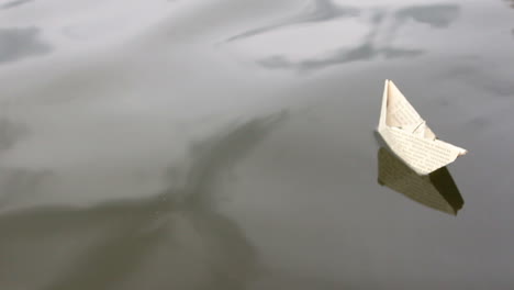 paper ship in children hand. the boy launches a paper boat into the water